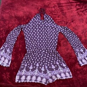 Cute and stylish plum colored romper with long sleeves, and cute floral pattern.